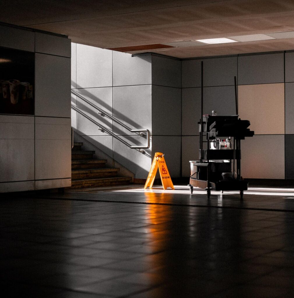 A janitorial cart and wet floor sign in a Hingham, MA office lobby after hours.