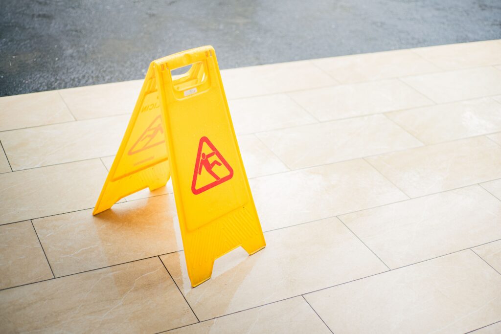 A wet floor sign marks an office entrance during day porter cleaning by Tully's Cleaning Company.